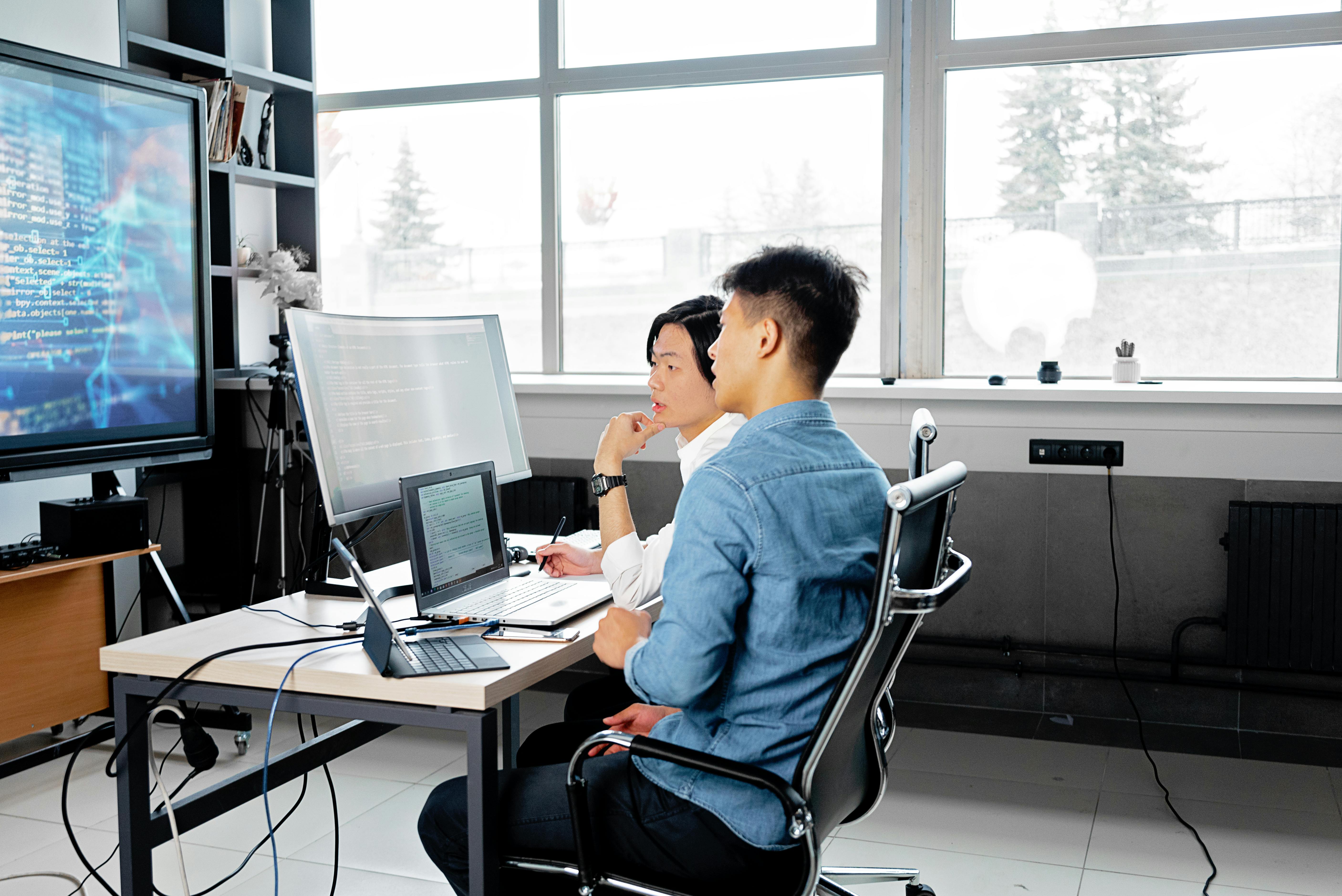 picture of two people reviewing code on a screen